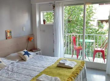 Sector dormitorio con vistas a la calle arbolada · Cálido Studio Monoambiente Amueblado con Cochera Opcional